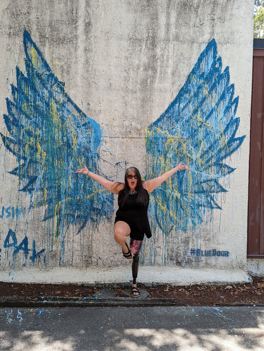 Marley Gibson with arms spread at angel wings mural in Savannah